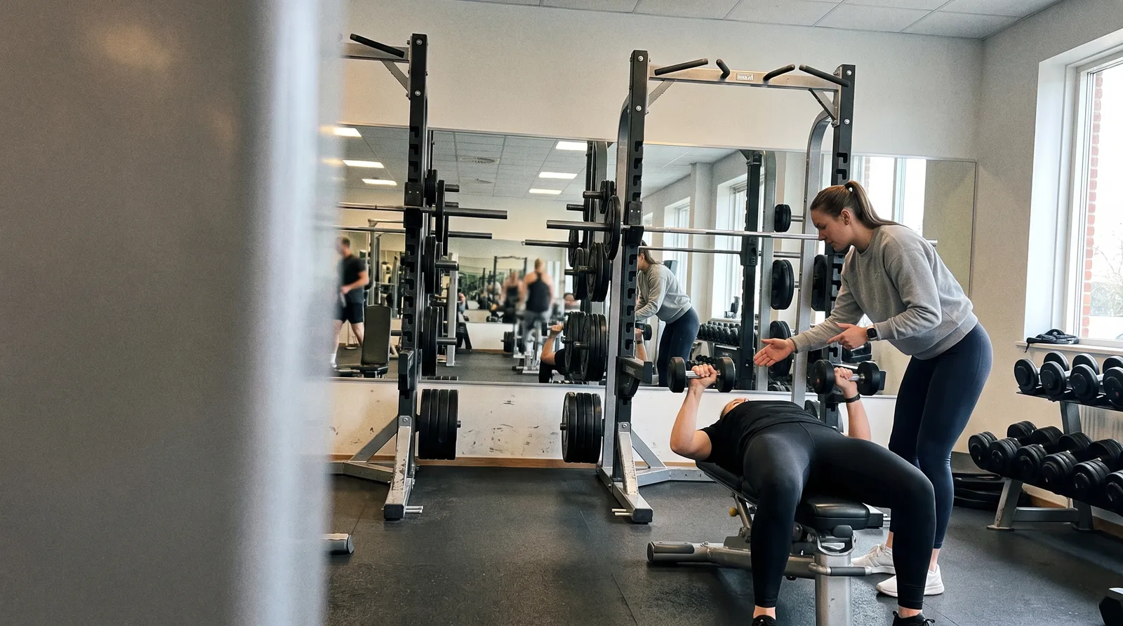 Personal trainer coaching a client in the gym